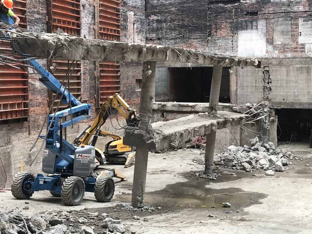 Construction equipment demolishing an old parking structure